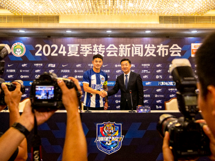 夏季转会窗口球员转会新闻发布会现场，球员与俱乐部代表握手